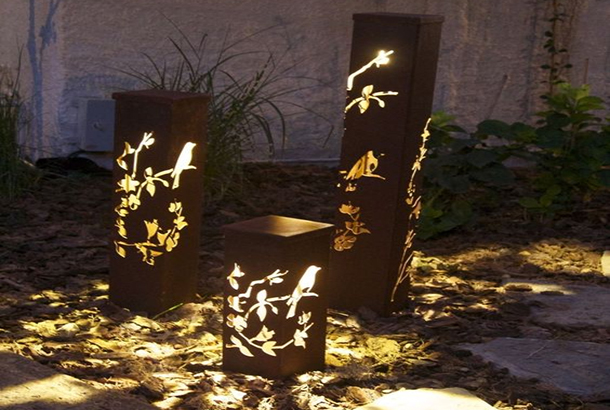 Hollowed corten steel garden bollard light creates artistic shadow